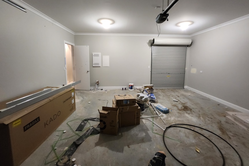 a room inside an unfinished partially built home, rubbish and building supplies are spread out on the floor