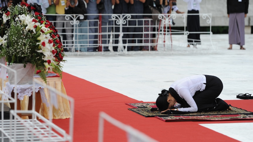 Aung San Suu Kyi prays at her father's tomb