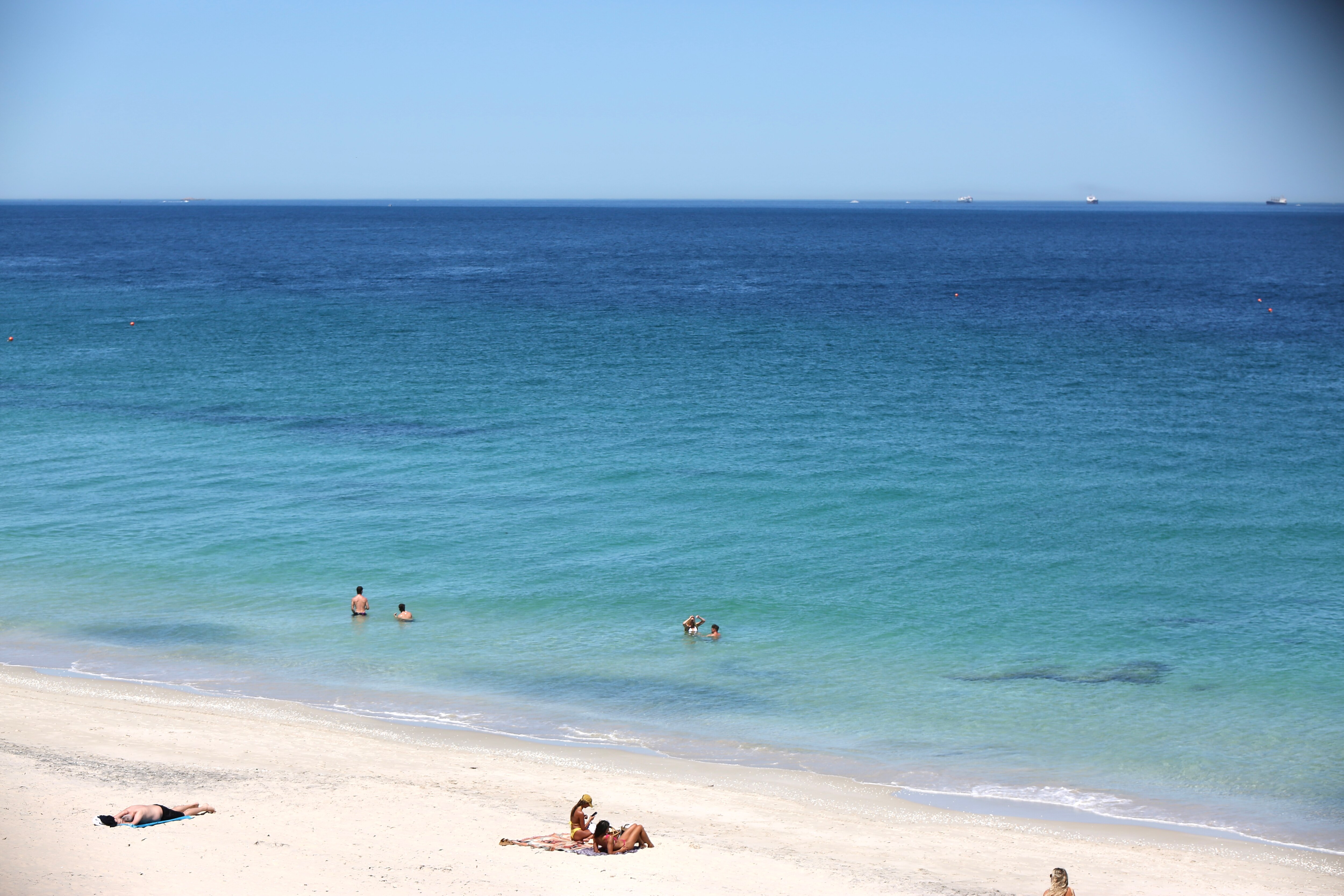 People and pets cool down at the beach during a February heat wave in Perth.