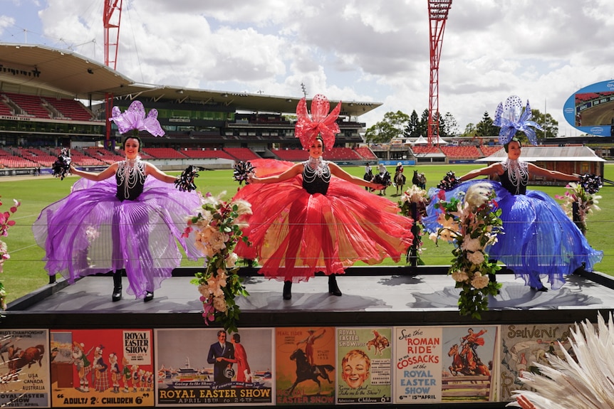 A float with three women in elaborate hats and skirts