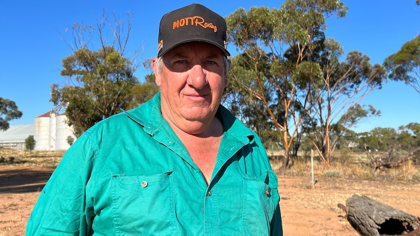 A man with a green shirt smiles at the camera. On his cap are the words "Mott Racing"