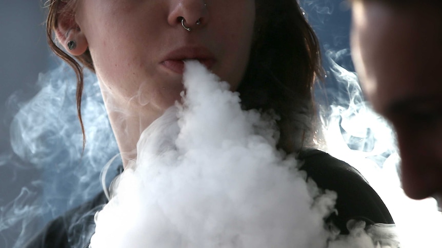 A woman smokes an e-cigarette in California