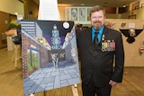 Adelaide veteran David Gillard stands next to one of his art pieces