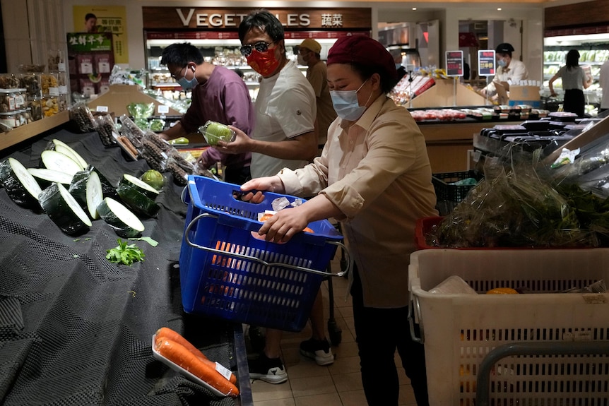 在北京的一家超市，购物者在光秃秃的蔬菜货架上查看。