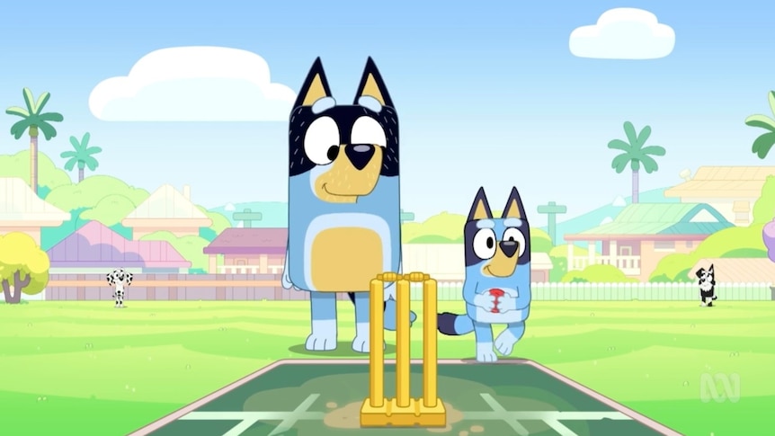 Bluey holds a cricket ball next to her dad, Bandit.