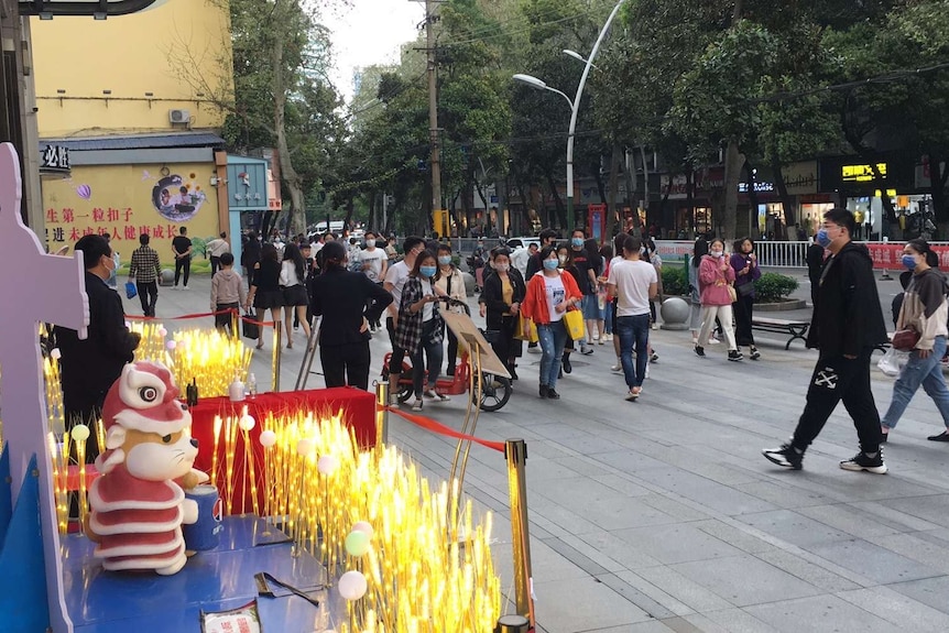 People wearing masks while walking down the street in China.