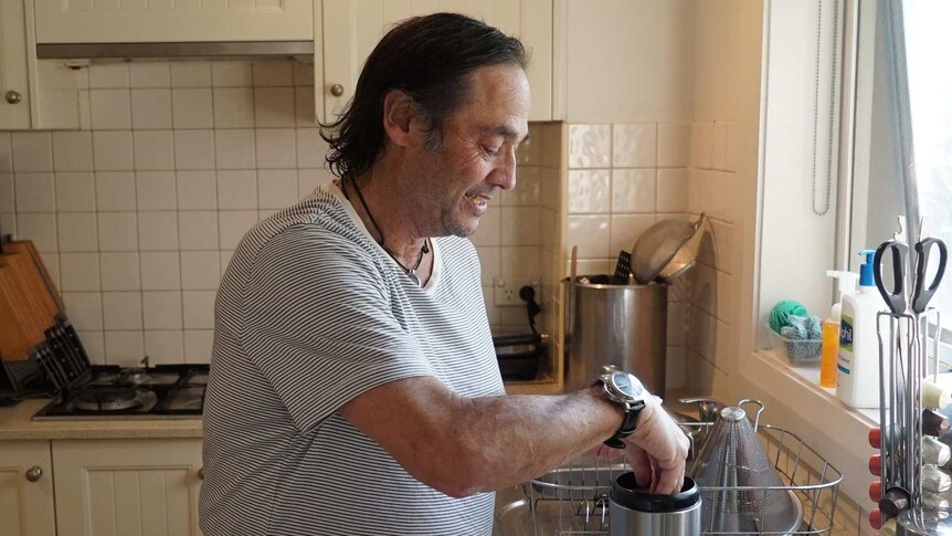 Palliative care patient Peter Morris makes a cup of tea in his apartment