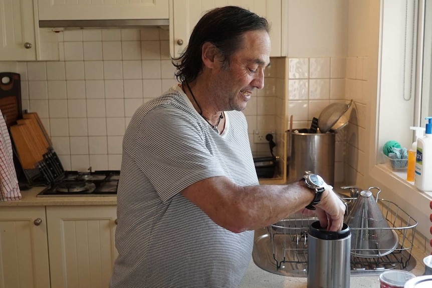 Palliative care patient Peter Morris makes a cup of tea in his apartment