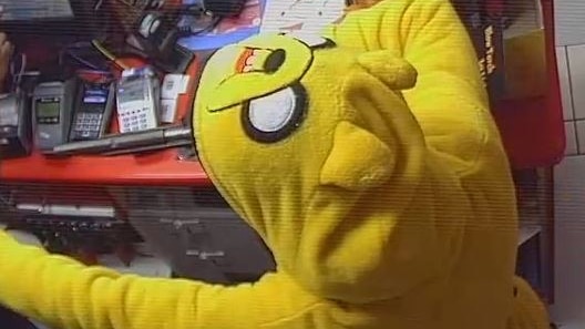 CCTV footage of a person wearing a yellow onesie jumpsuit of Jake the Dog from Adventure Time, brandishing a handgun
