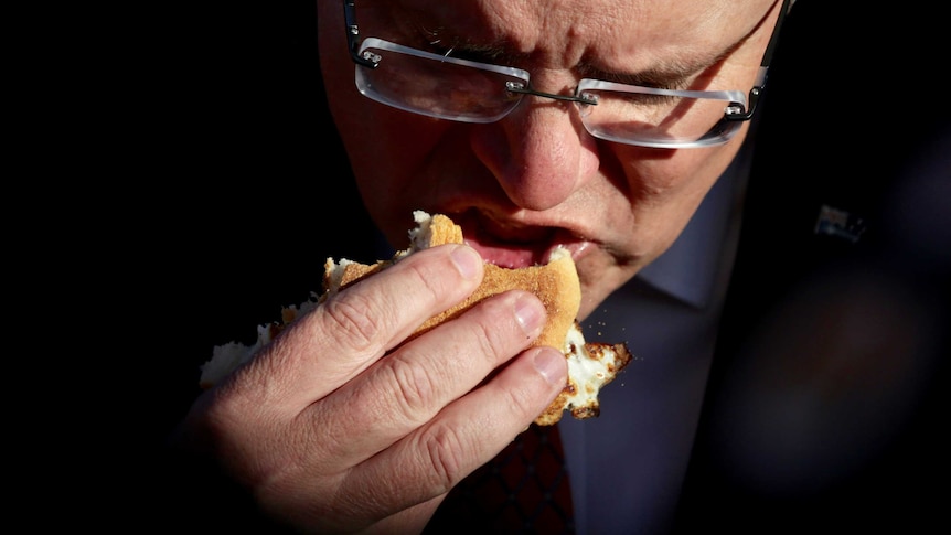 Close up of Scott Morrison eating an egg and bacon roll