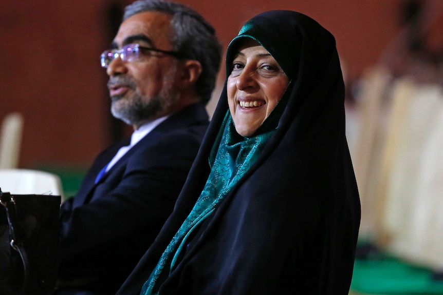 Masoumeh Ebtekar sits at a table next to a man.