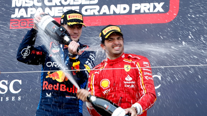 Max Verstappen sprays wine onto Ferrari driver Carlos Sainz on the podium.