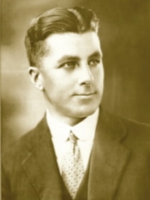 a sepia toned photo of a man smiling at the camera