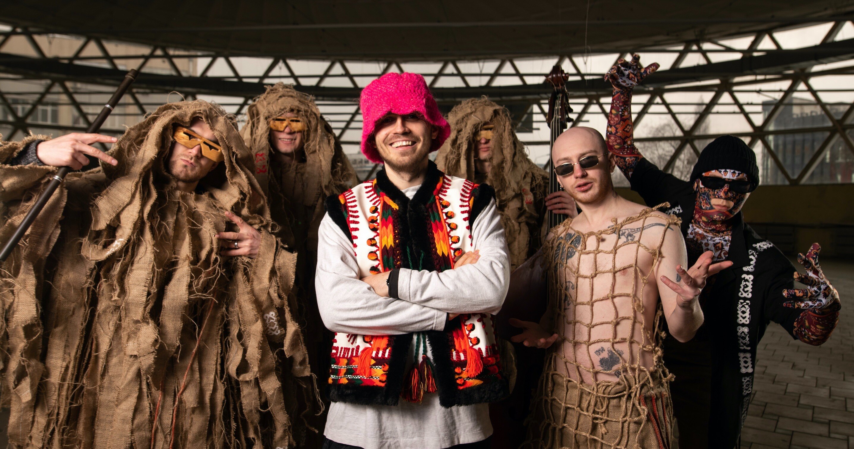 Six artists of a music band stare at the camera in dress