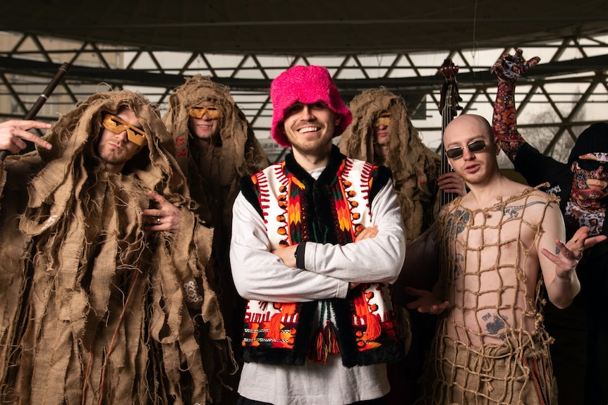 乐队的六位艺人在穿着打扮时盯着镜头