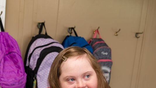 Newcastle teenager Katinka Pettet in a red shirt, smiling, in a new walker.