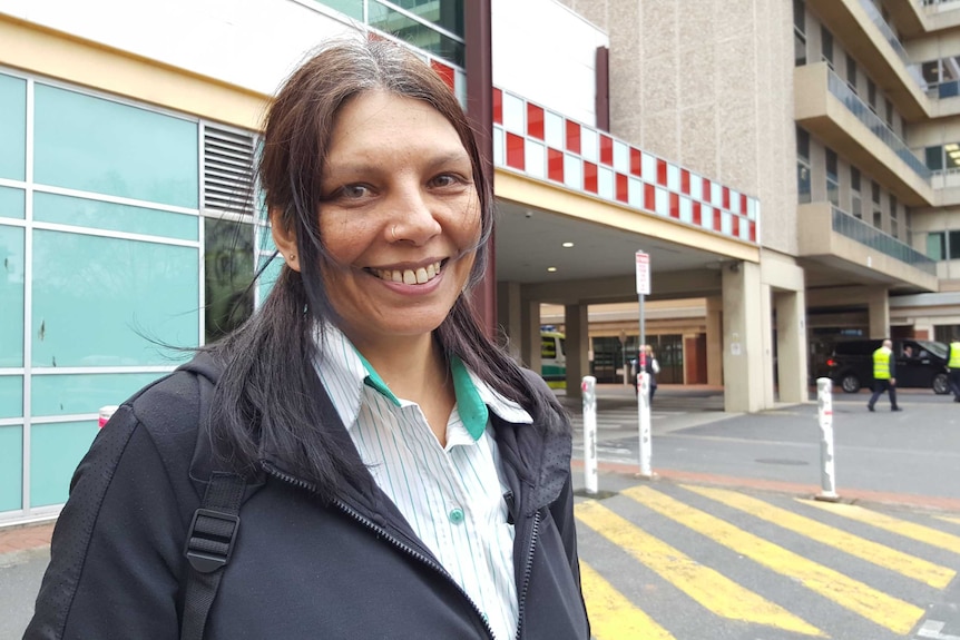 A nurse stands out the front of a hospital emergency department