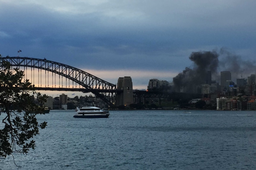 A black plume of smoke rises from the Sydney Harbour Bridge.