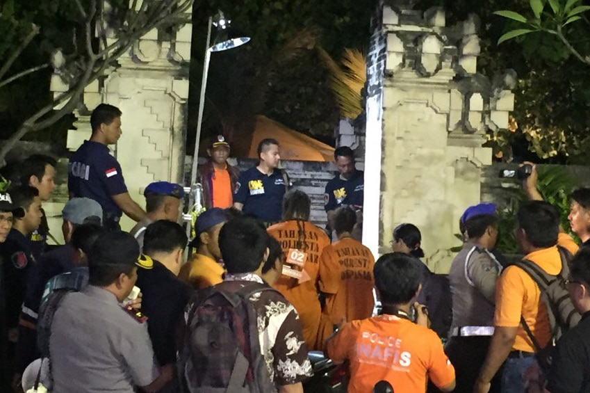 Murder accused Sara Connor and David Taylor, wearing orange jumpsuits, are surrounded by media and police on Kuta beach, Bali.