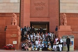Indian lawmakers pose for a photo on the stairs of the parliament building.