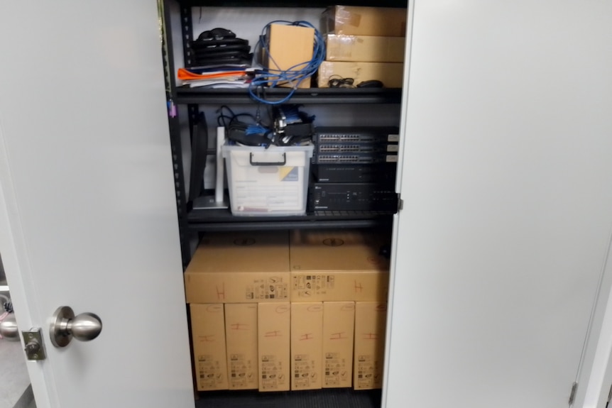 Computers and technologiocal equipment in a cupboard at Cairns School of Distance Education