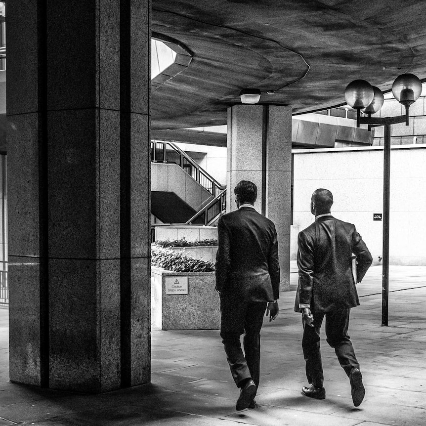 Two men walking in suits