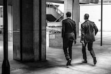 Two men walking in suits