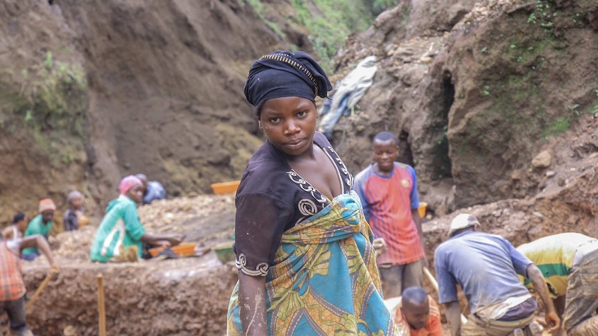 A woman in colourful clothes looks at the camera