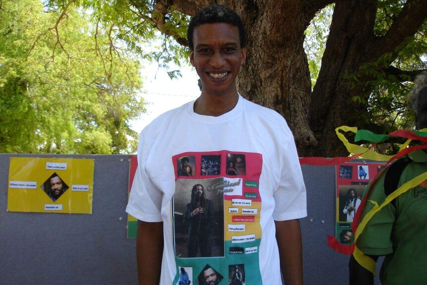 A man wearing a tshirt featuring musician Lucky Dube smiling to the camera.