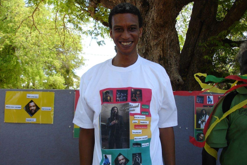 A man wearing a tshirt featuring musician Lucky Dube smiling to the camera.