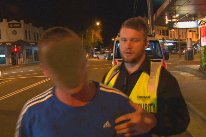 A security guard restrains a man outside the Cock 'n Bull pub in Bondi Junction after a brawl.