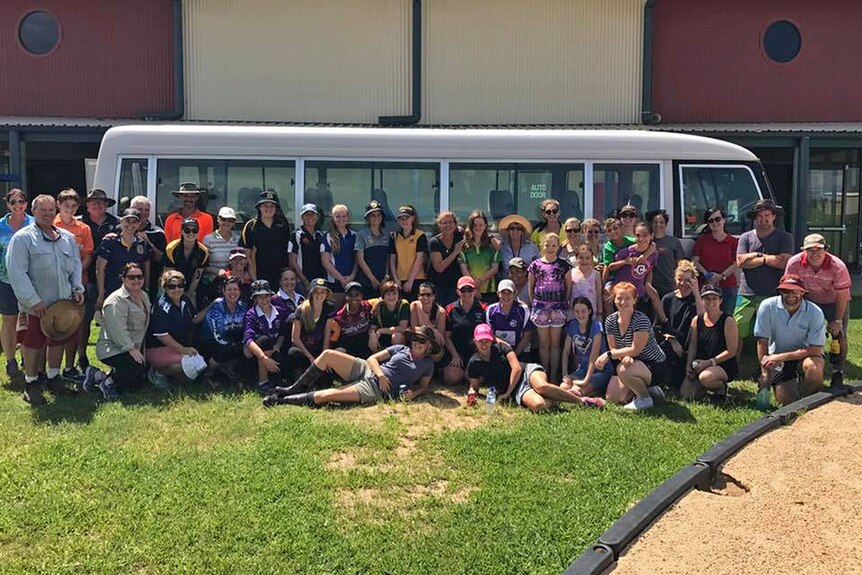 Students and volunteers out the front of a damaged Proserpine school.