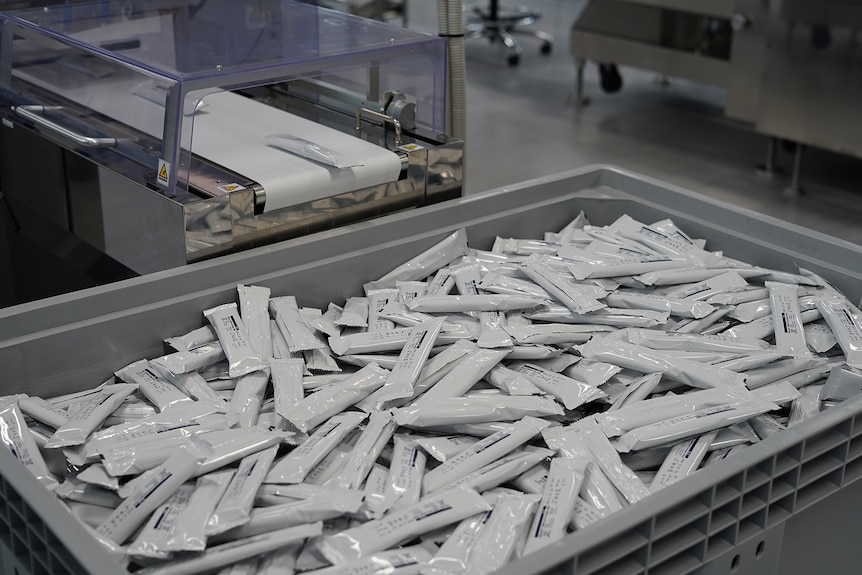 Tests going down a conveyor belt and into a bucket.