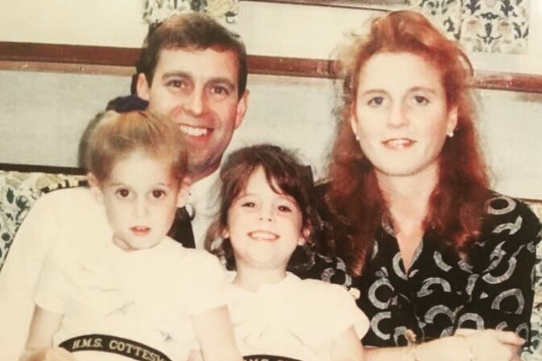 Prince Andrew and Sarah Ferguson smiles with their daughters sitting on their lap smiling.