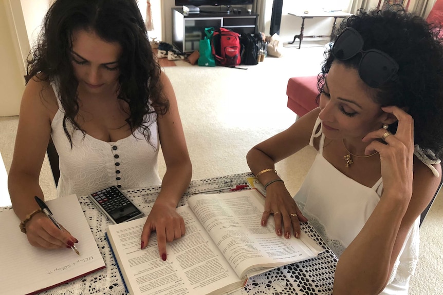 A mother and daughter homeschooling at the books