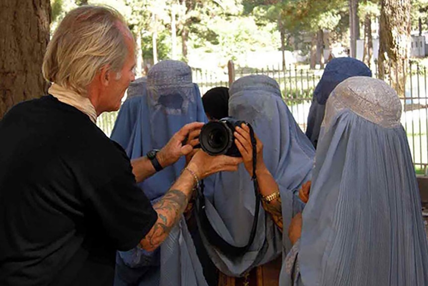 A group of girls in Kabul, Afghanistan, inspect Sebastian Rich's camera