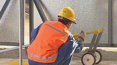A worker paints a cart.