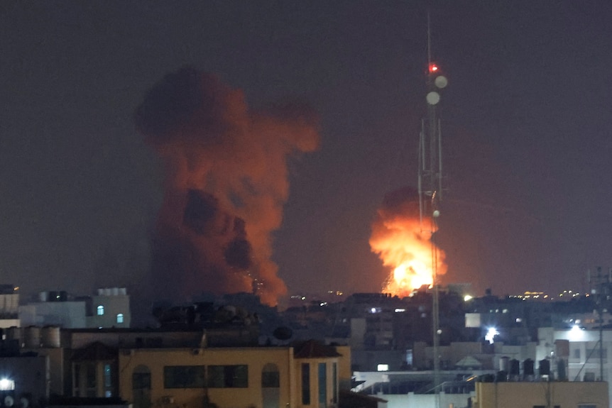Smoke and flame are seen during Israeli air strikes in the night sky.