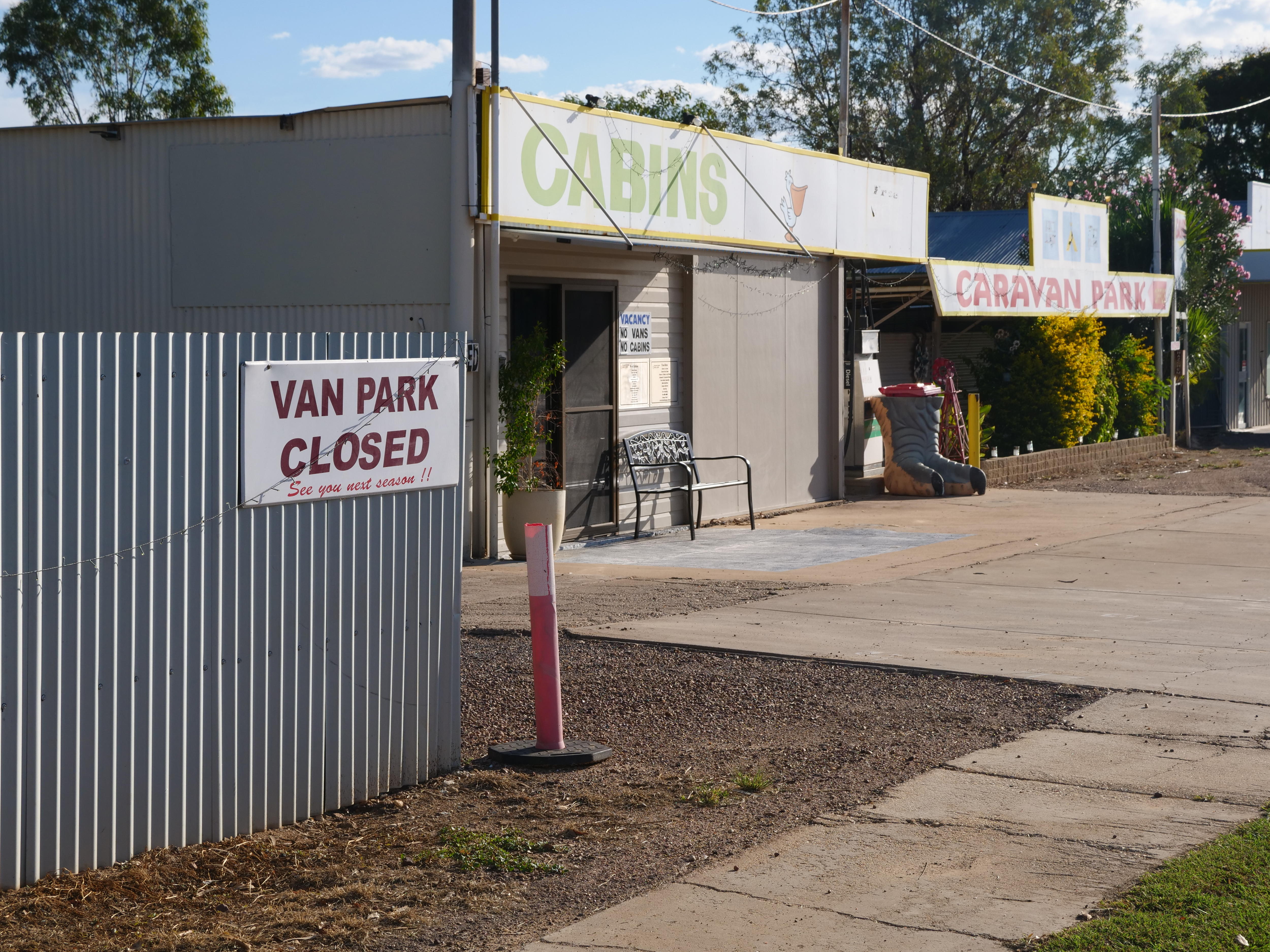 A caravan park with a closed sign at its entrance.