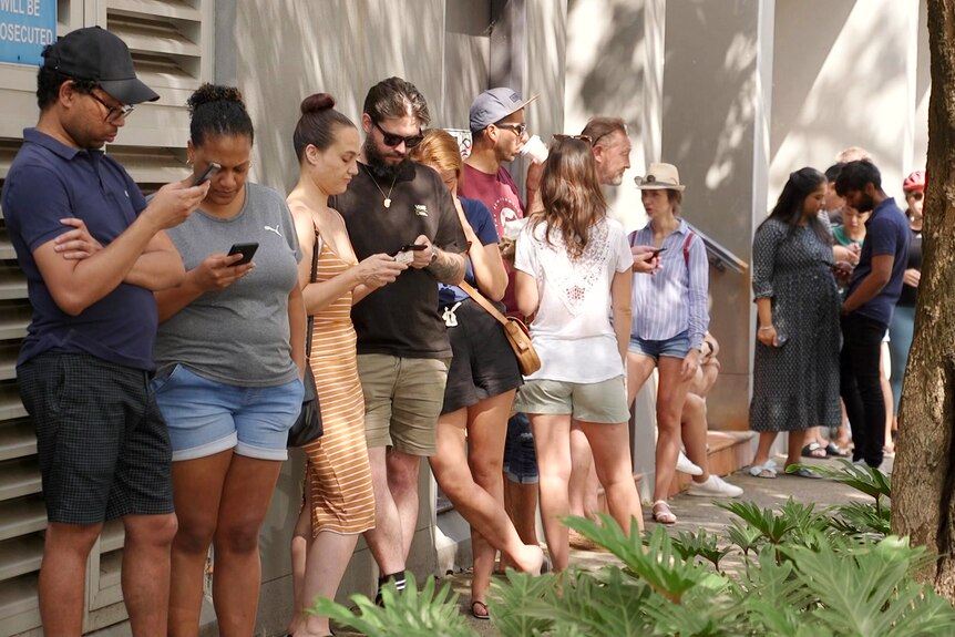 people waiting in line outside to view a rental property