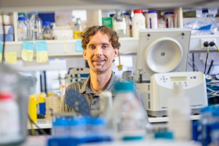 University of Queensland researcher Dr Chris Rinke sits in a lab.