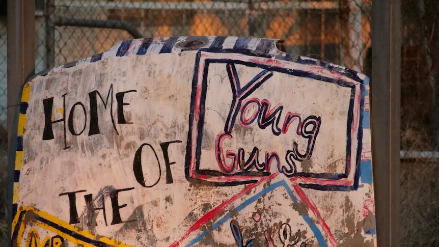 A hand painted sign declares Alpurrurulam as 'The Home of The Young Guns'.