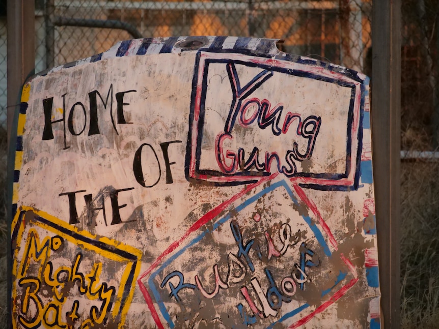 A hand painted sign declares Alpurrurulam as 'The Home of The Young Guns'.