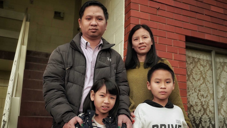Jacky Pham and family standing on the steps of their house, Hobart, May 2020.