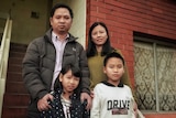 Jacky Pham and family standing on the steps of their house, Hobart, May 2020.
