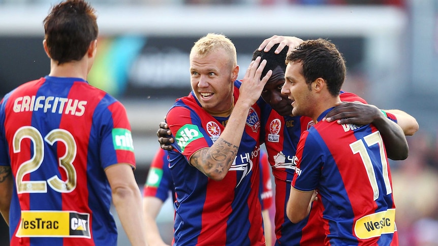 Taylor Regan and James Virgili of the Jets congratulate team-mate Emile Heskey after he scored during the round three A-League match last year.