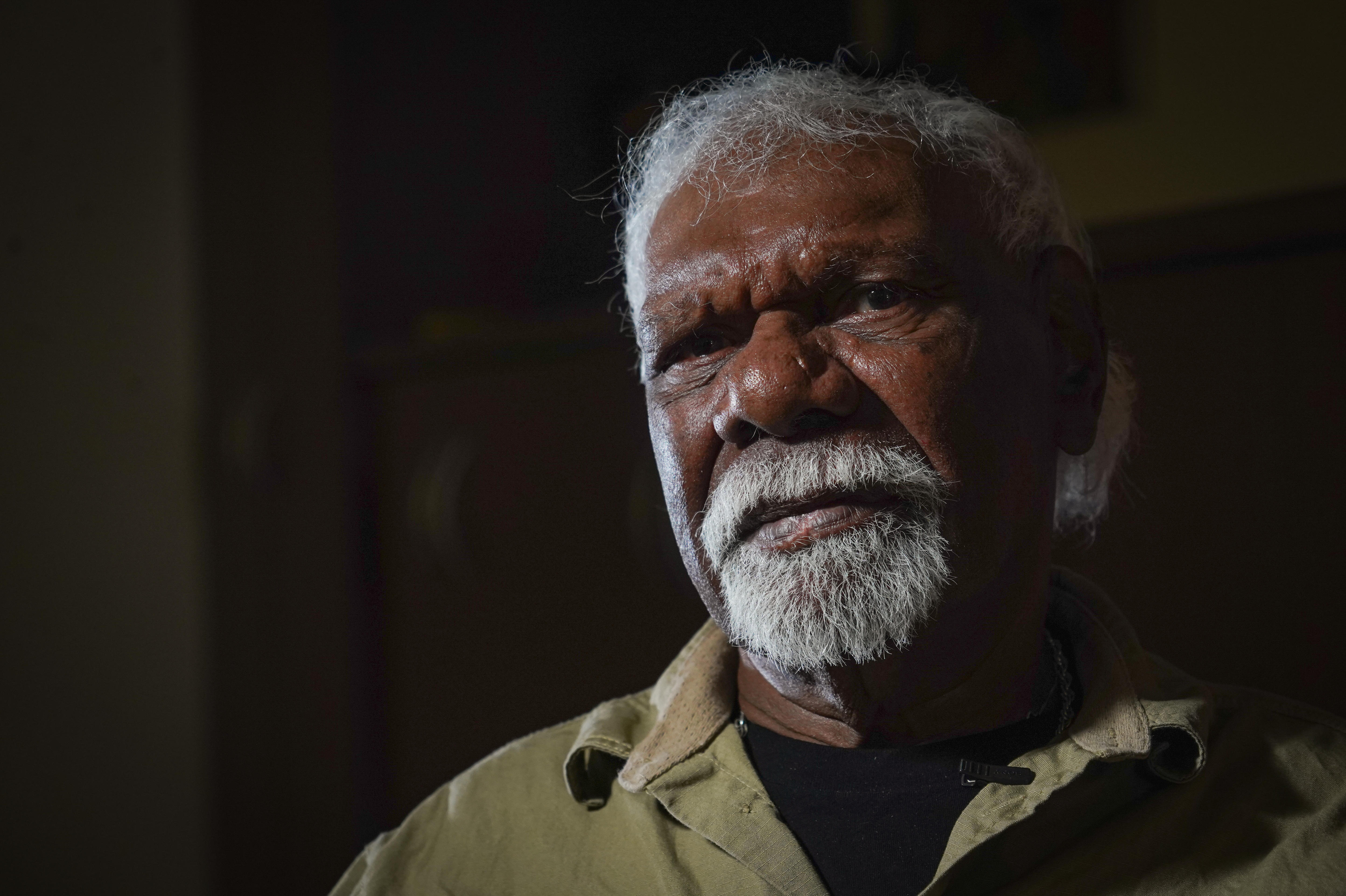 A man in an olive shirt with a goatee