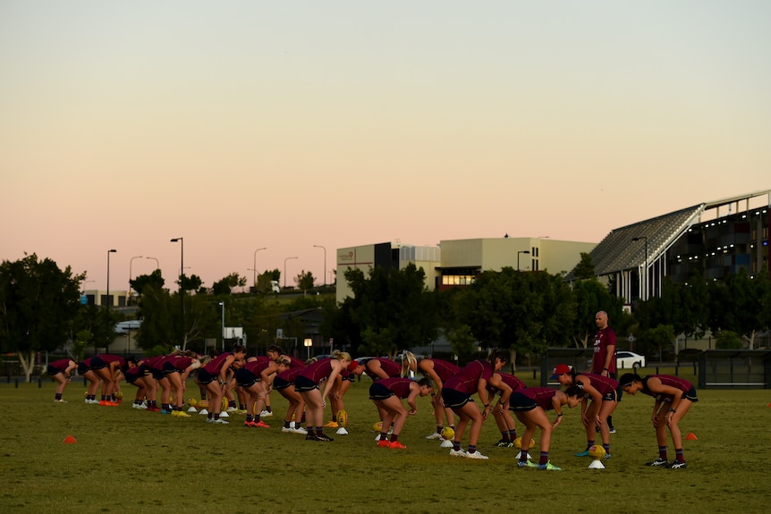 Brisbane Lions AFLW team train under the setting sun