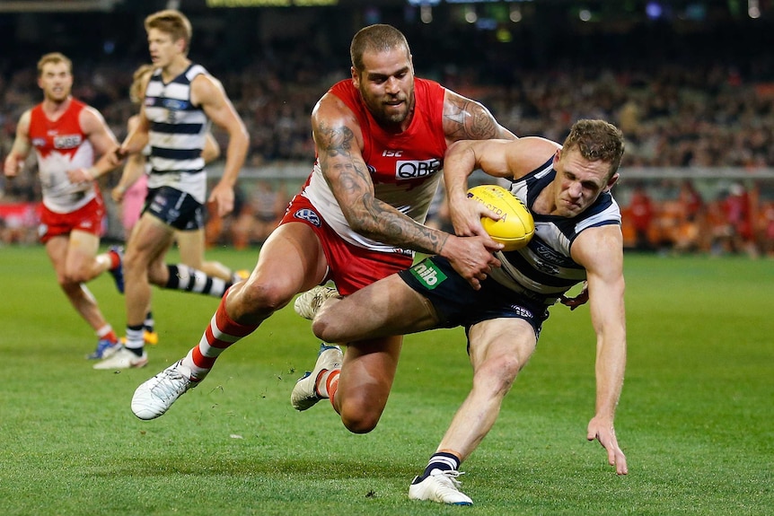 Joel Selwood is tackled by Lance Franklin