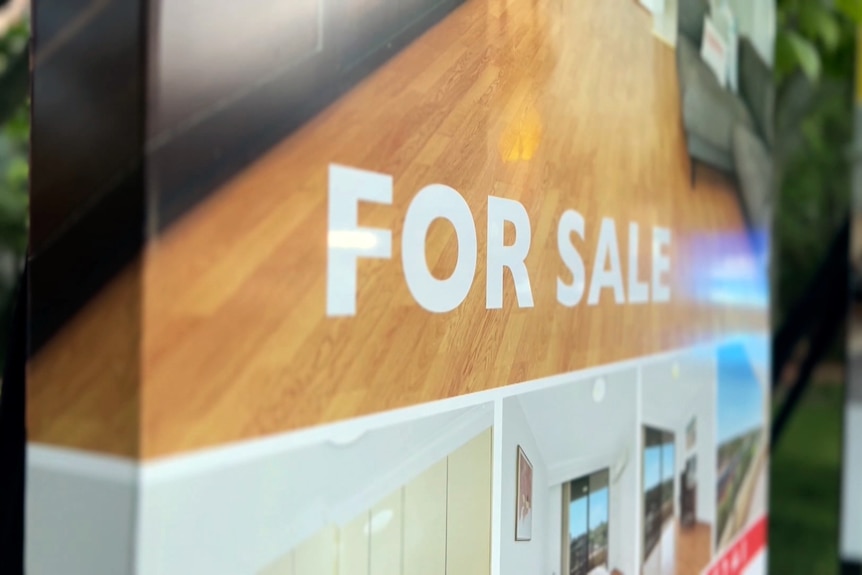 A close up of the words 'for sale' on a real estate sign outside a property.